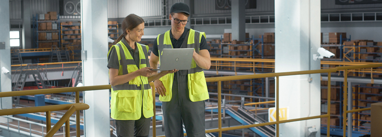 Two distribution center employees talking on a mezzanine.
