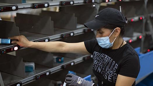 Employee using put wall solution from Lightning Pick to sort ecommerce orders.