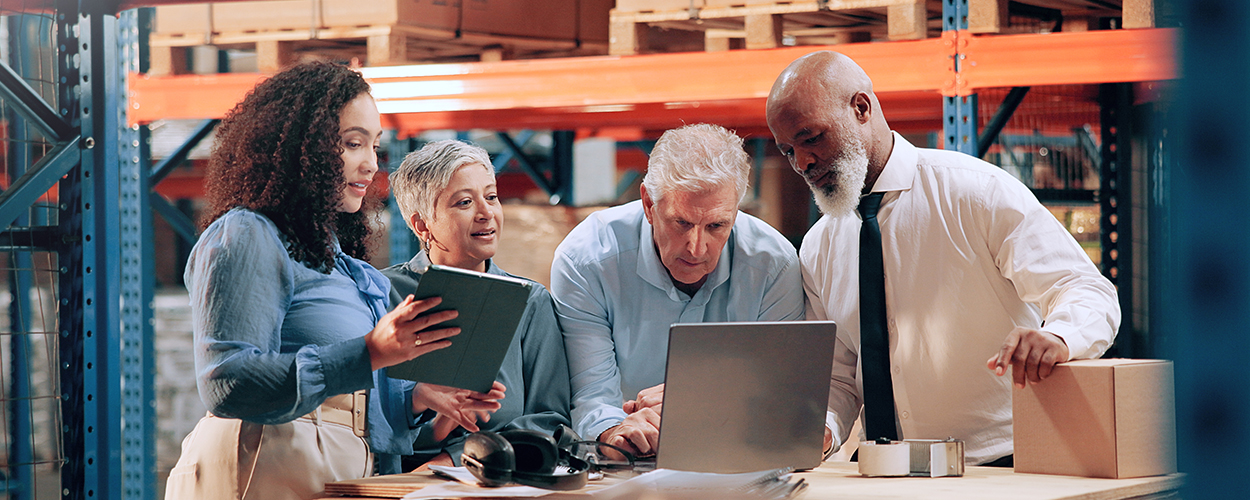 Lightning Pick partners gathering around a laptop in a distribution center.