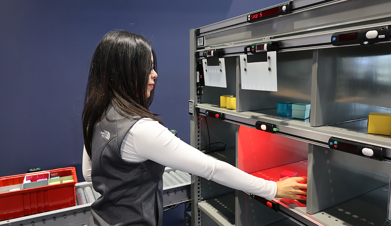 Woman sorting orders with a Put Wall from Lightning Pick for ecommerce order fulfillment.